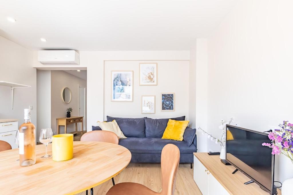 a living room with a blue couch and a table at AK Magnifique et spacieux 3 pièces, vue mer in Antibes