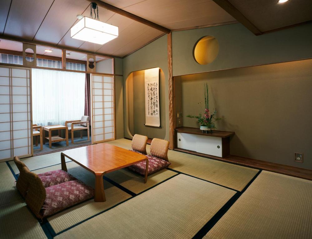a living room with a wooden table and chairs at Kinparo in Kyoto
