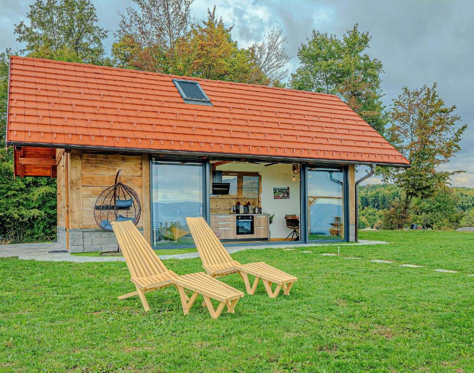 two chairs sitting in the grass in front of a house at Vineyard cottage Pri mali luži in Trebelno