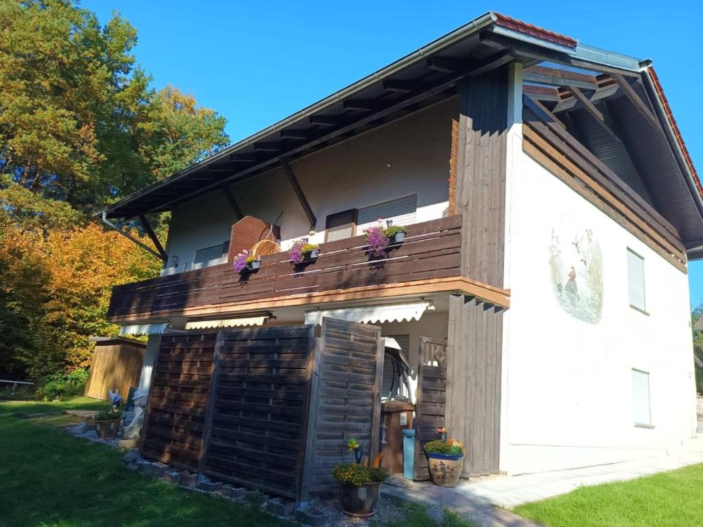 a building with a balcony with flowers on it at Ferienwohnung Herzmensch in Tiefenbach