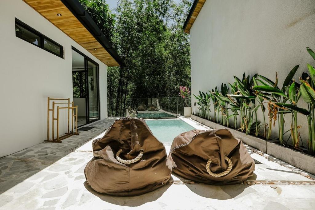 two bags on the ground next to a swimming pool at Villa Tamu 2 in Bingin Beach