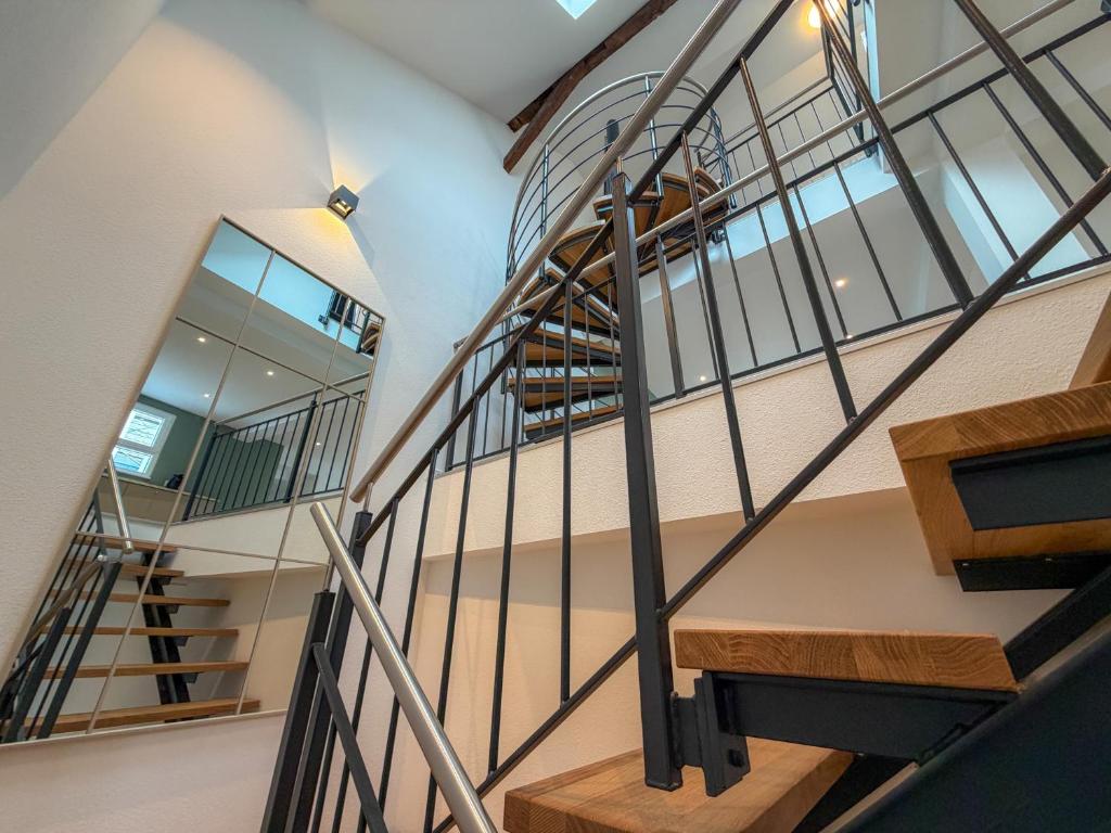 a winding staircase in a house with wooden treads at Heimwärts - Altstadt-Weingut mit Dachterrasse in Bad Neuenahr-Ahrweiler