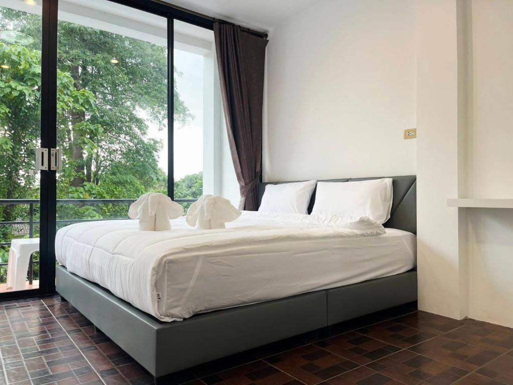 a bed in a room with a large window at At Mutta Lanta House in Ko Lanta Yai