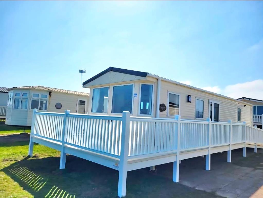 Mobilheim mit einem weißen Zaun in der Unterkunft Sea Bliss Beachfront Caravan, 2 Bed King Ensuite, Sleeps 6, Wrap Decking, Crimdon Dene in Hartlepool
