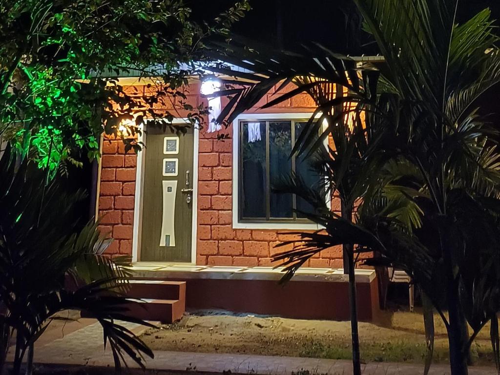 una casa con una puerta y una ventana por la noche en Coastal Home, en Diveagar
