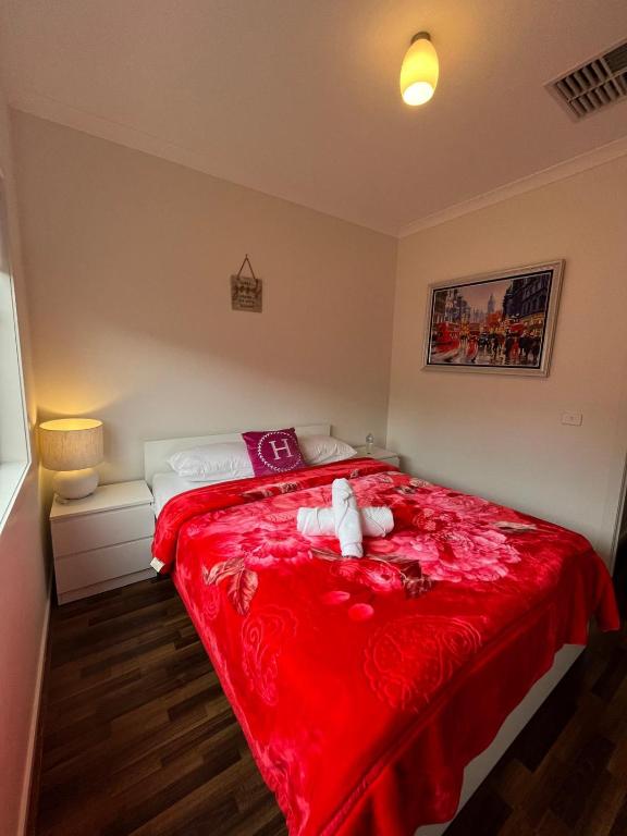 a teddy bear laying on a bed in a bedroom at My Home in Truganina