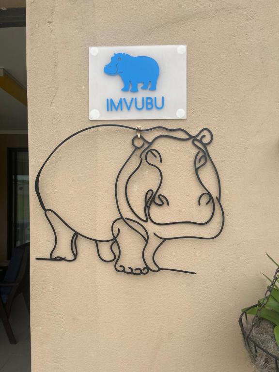 a sign with a bear and a baby elephant on a wall at Imvubu Chalet in Sodwana Bay