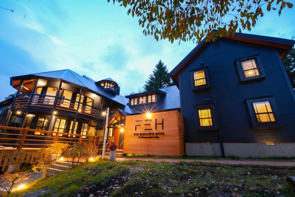 a large blue house with a garage in front of it at Fuji Elegance Hotel in Yamanakako