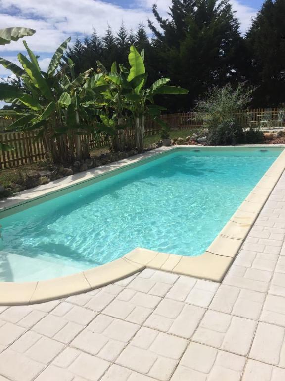 a swimming pool with blue water in a yard at Villa paisible avec piscine in Bercloux