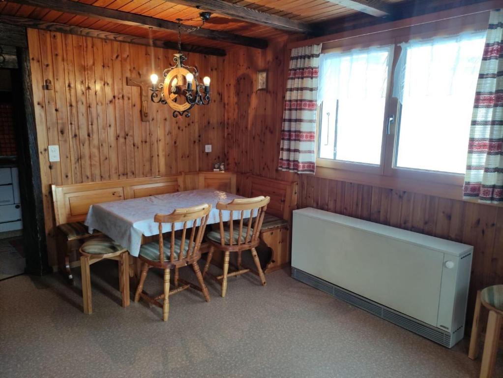 a dining room with a table and chairs and a chandelier at Chalet Lueg uf Belalp in Rosswald
