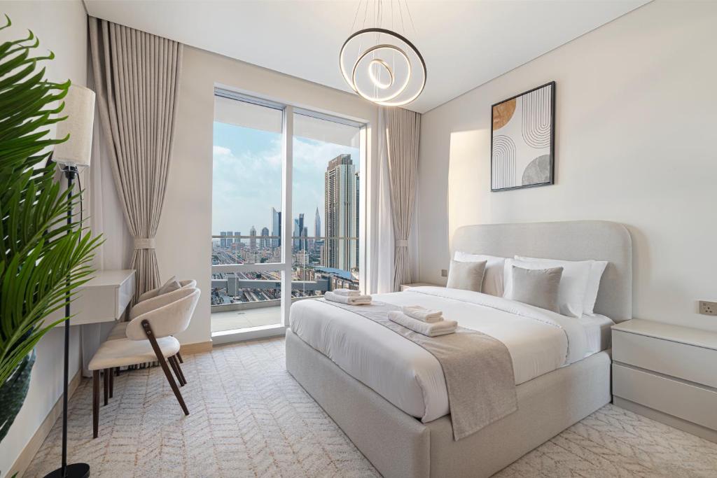 a white bedroom with a bed and a large window at Vida Dubai Mall! 2 Bedroom with Burj Khalifa View! Direct Access to Dubai Mall in Dubai