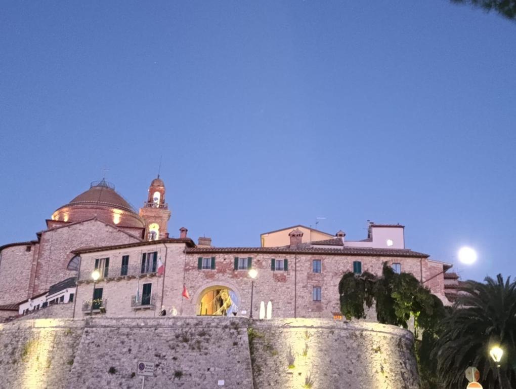een gebouw achter een stenen muur 's nachts bij La Gatta sul Tetto in Castiglione del Lago