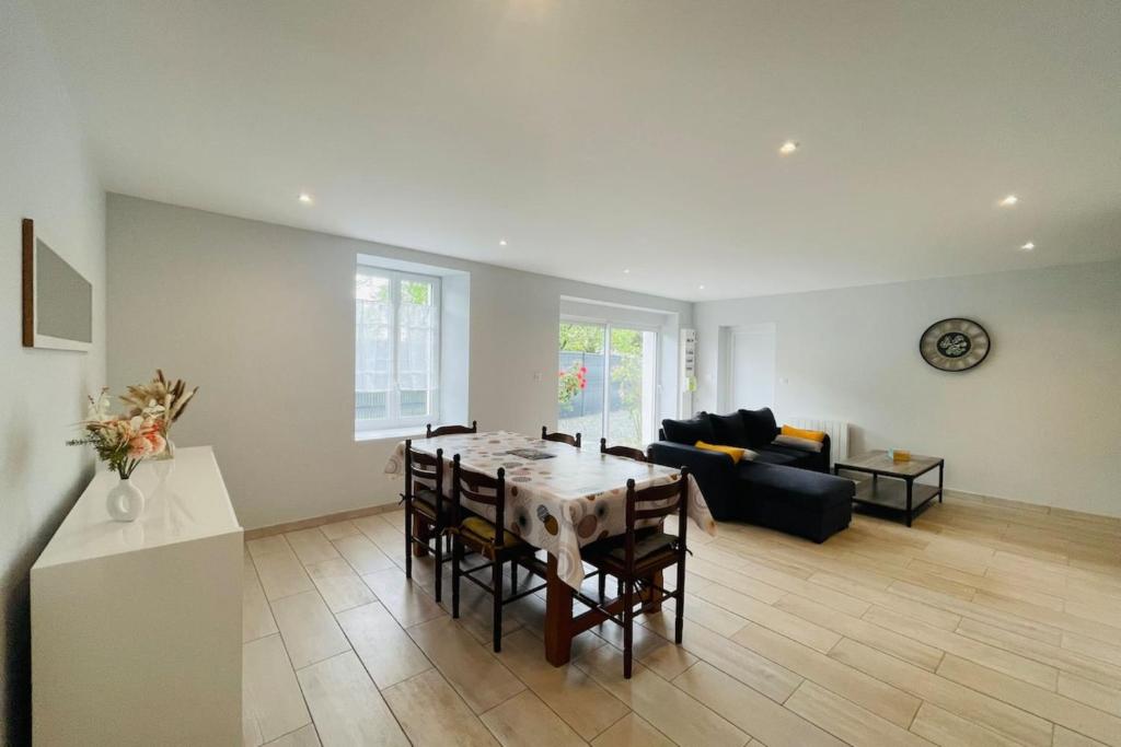 ein Wohnzimmer mit einem Tisch und einem Sofa in der Unterkunft Maison les mottes-cour et garage in Asnières-la-Giraud