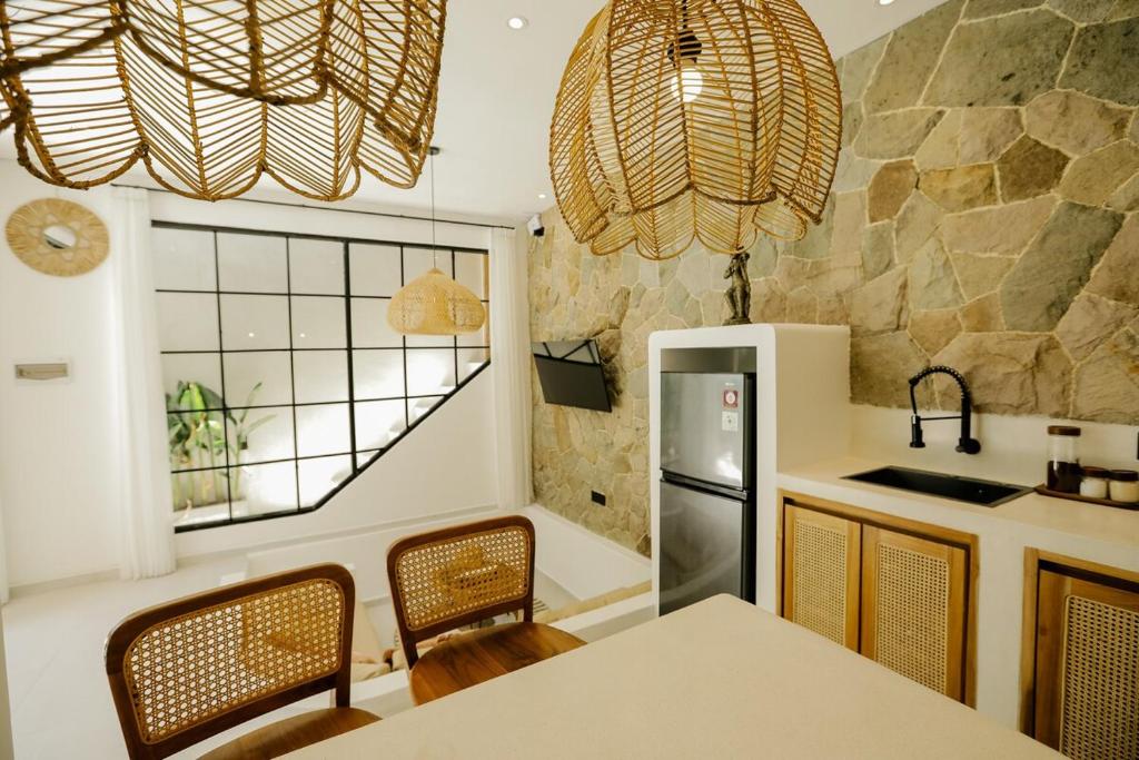 a kitchen with a table and chairs and a counter top at Villa Tamu 3 in Bingin Beach