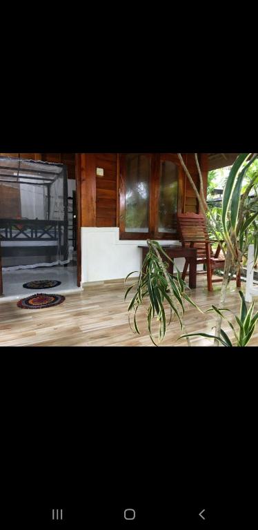 a living room with a table and a plant at Gems Garden Guest House in Tangalle