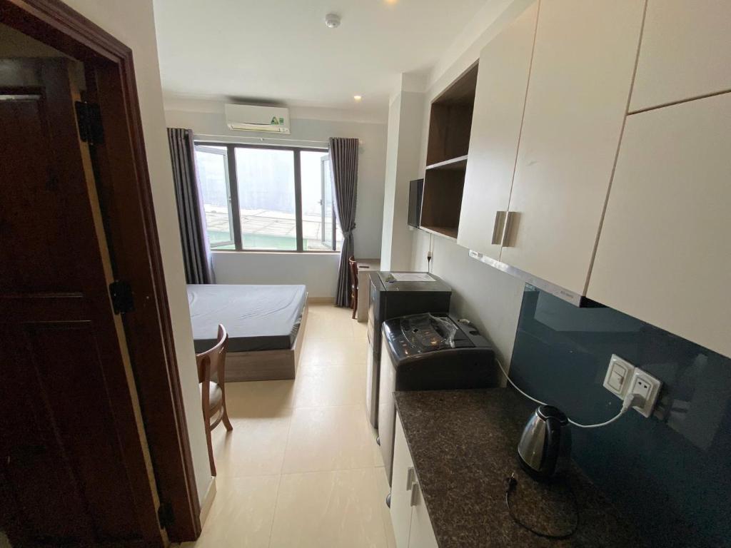 a small room with a bed and a kitchen at Landmark Signature Residences Ori-Stay in Kon Rung (1)