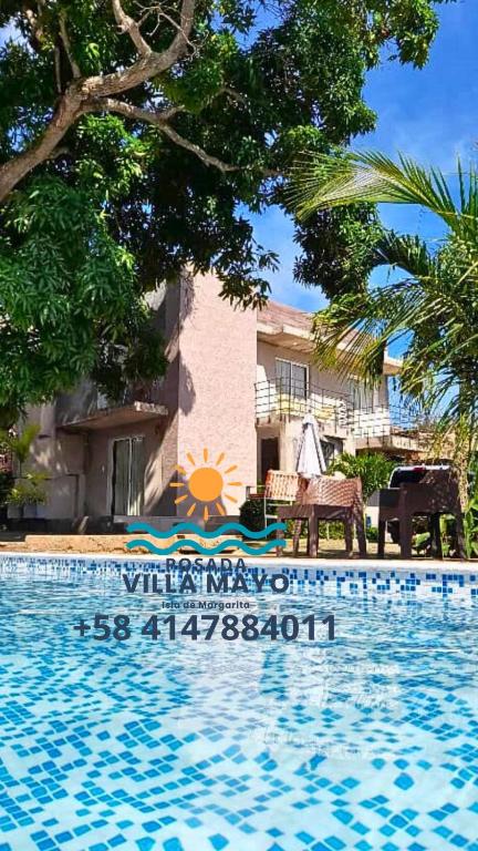 ein Resort mit einem Pool vor einem Haus in der Unterkunft Habitación Triple Equipada, Posada Villa Mayo a 5 minutos de Playa Parguito in Loma de Guerra