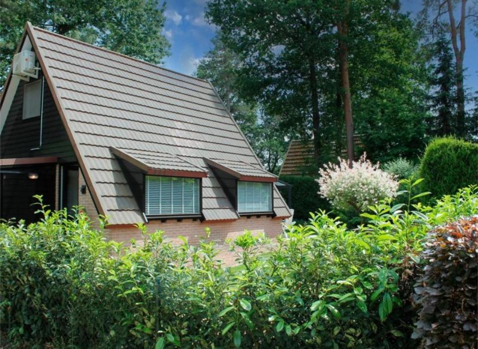 a house with a gambrel roof with two windows at Boshuisje Rekem Charly in Lanaken