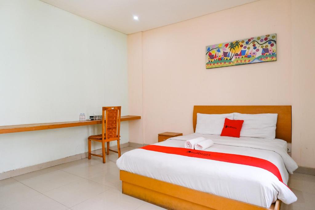 a bedroom with a bed and a desk in it at RedDoorz Plus @ Mahendradatta Denpasar in Denpasar