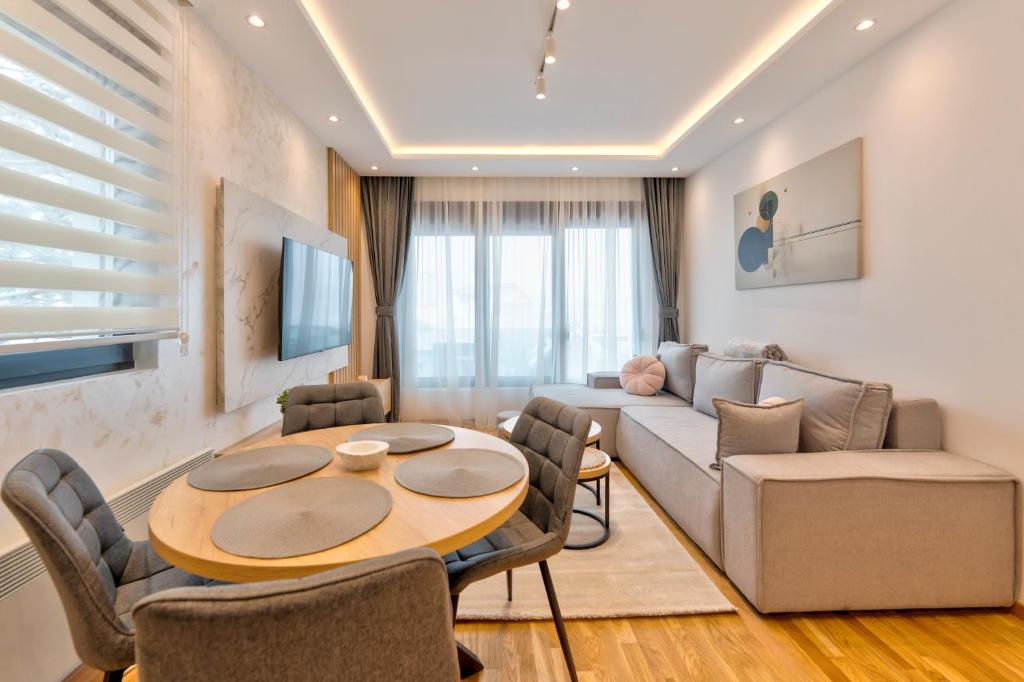 ein Wohnzimmer mit Tisch und Couch in der Unterkunft Apartmani Gomax 3,4 & SPA Zlatibor in Zlatibor