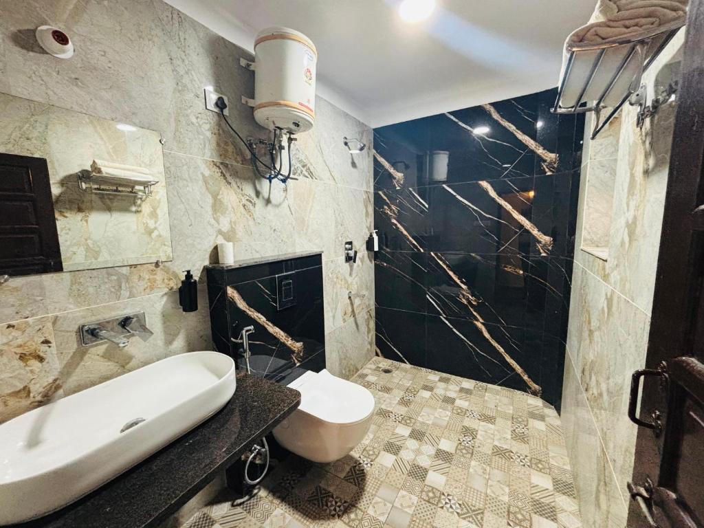 a bathroom with a sink and a toilet in it at Sajjan Bagh Resort in Pushkar