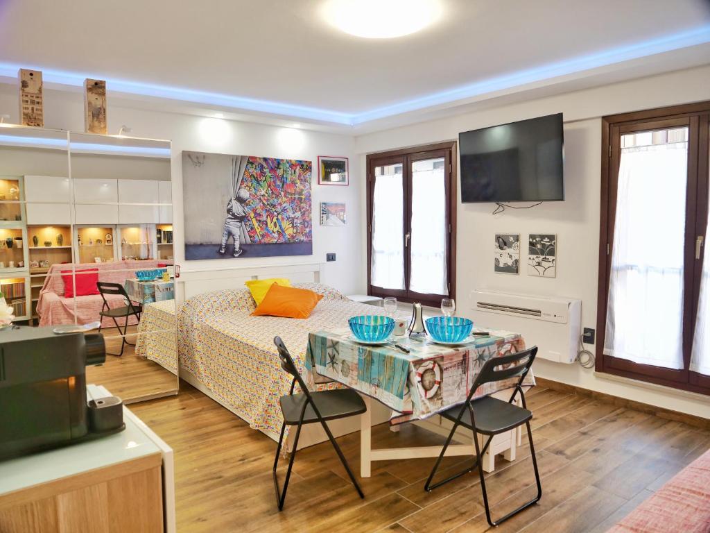 a room with a bed and a table with chairs at LaTanaDiFedro - Monolocale tra centro storico e mare in Grado