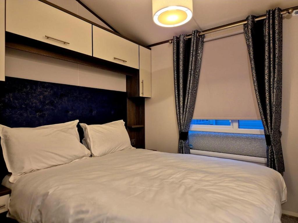 a bedroom with a large white bed with a window at Sirrah Villa - Whitstable, Family & Pet friendly in Seasalter