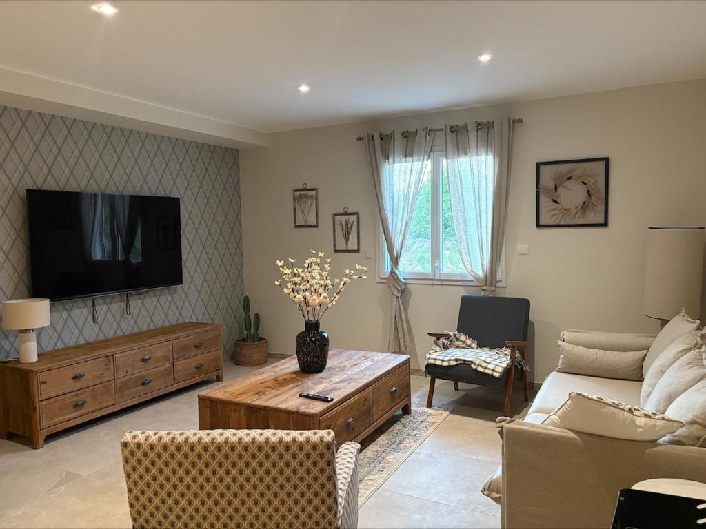 ein Wohnzimmer mit Sofa und Fernseher in der Unterkunft Villa des Roches - Labeaume in Labeaume