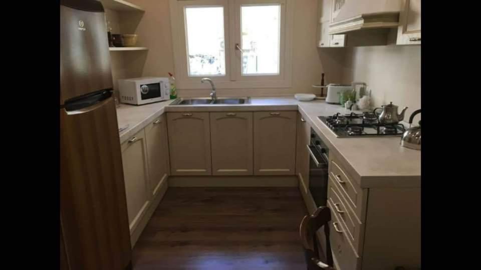 een kleine keuken met een spoelbak en een magnetron bij Modern two bedroom apartment in Valletta in Is-Swatar