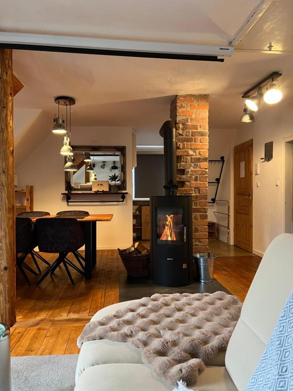 a living room with a fireplace and a table at gemütliche rustikale Wohnung mit Kamin und optionalem Whirlpool in Bad Sobernheim