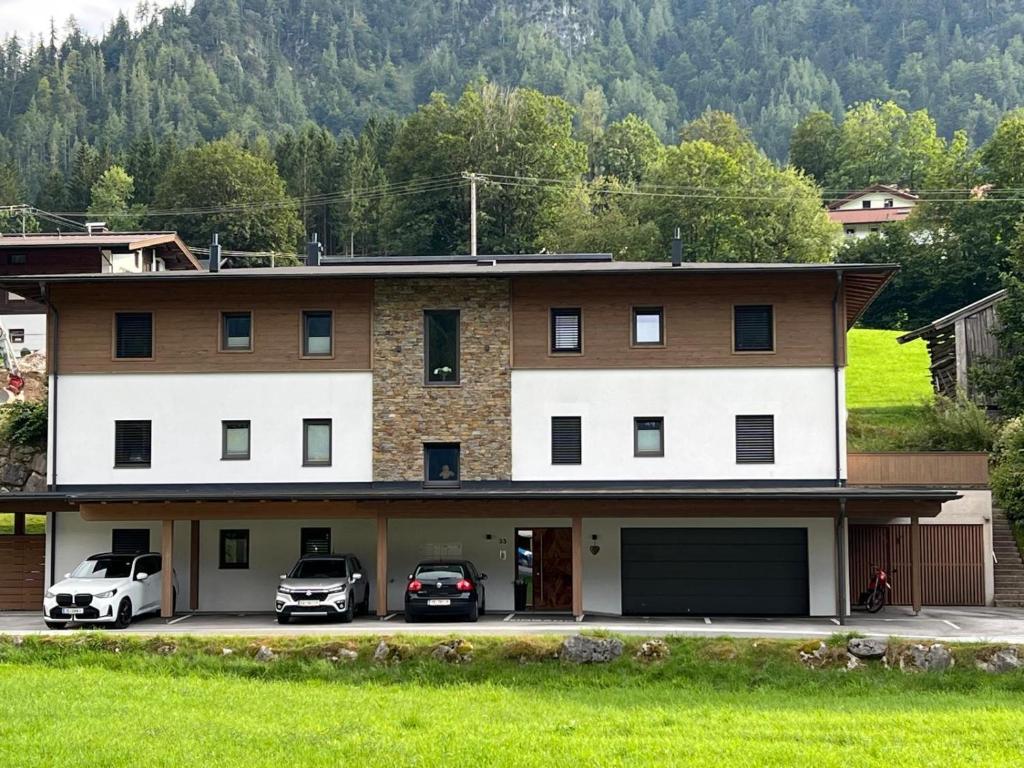 a house with two cars parked in front of it at Haus Steinplatte in Waidring
