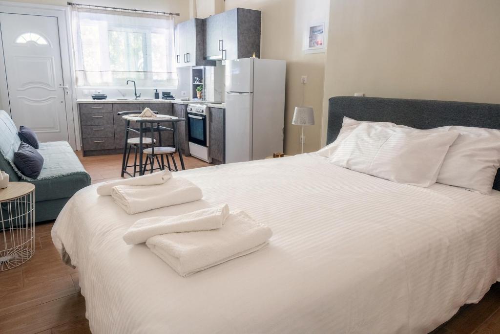 a bedroom with a large white bed with towels on it at Γκαρσονιέρα 1 δίπλα στη θάλασσα! in Antikyra