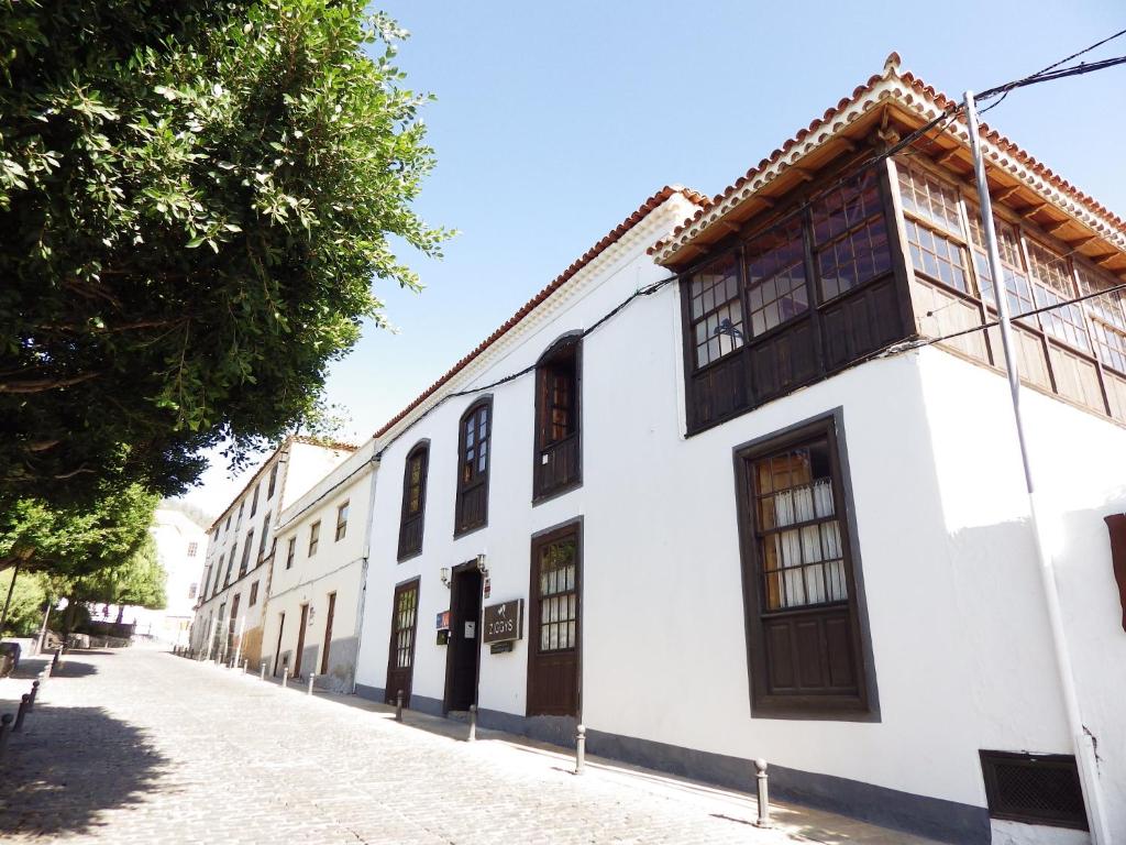 a white building with wooden windows on a street at Ziggy's Mountain Retreat in Vilaflor