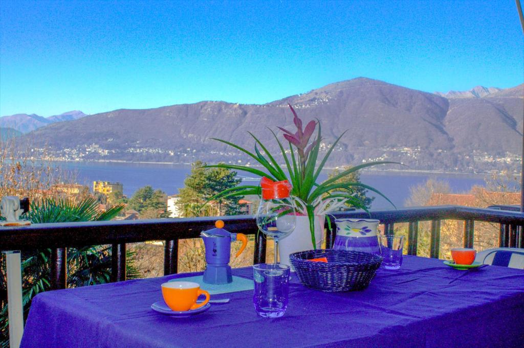 a table with a purple table cloth with a view of a mountain at Casa Marica in Porto Valtravaglia