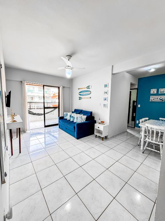 a living room with a blue couch and a table at Hospedatom - Apartamento Economy Prainha Arraial do Cabo in Arraial do Cabo