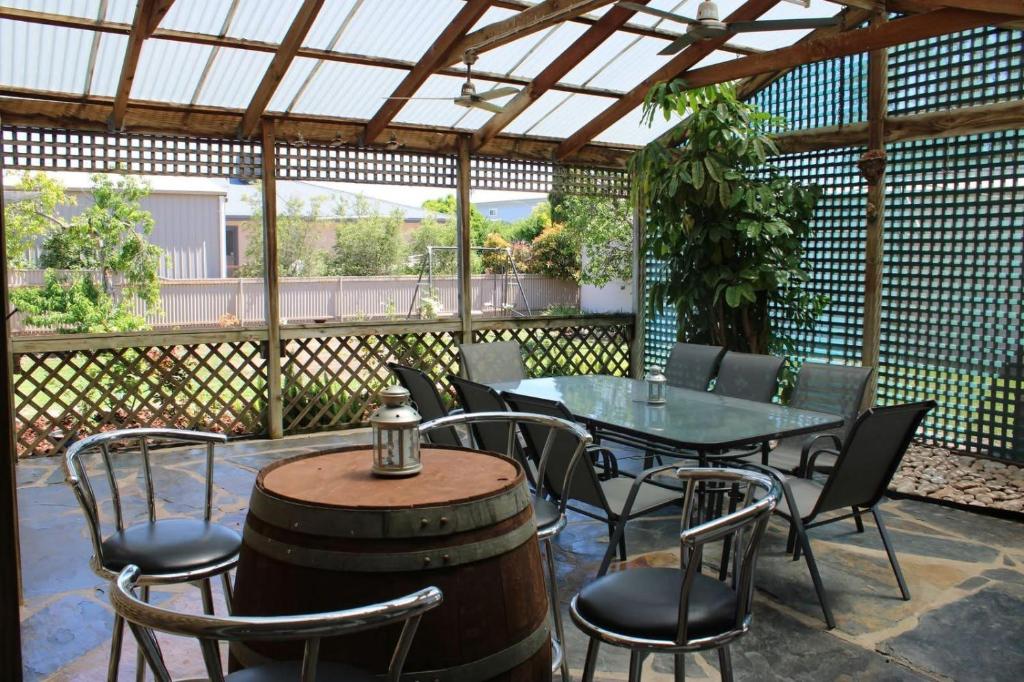 patio con tavolo, sedie e botte di Paradise at Port Hughes - Family Beach Escape a Port Hughes