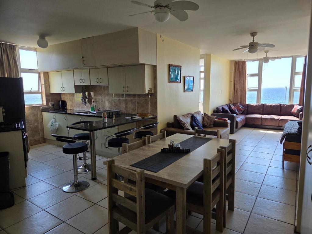 a kitchen and living room with a table and chairs at Peacehaven Beachfront Property - Scottburgh KZN in Scottburgh