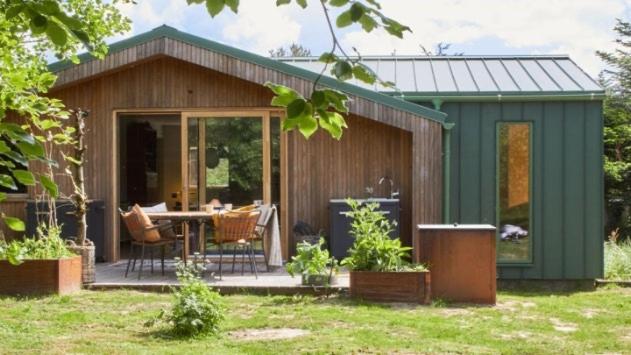 a small shed with a table and chairs in a yard at Wonderful Family House At The West Coast in Løkken