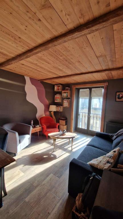 a living room with a couch and a table at chaleureux cocon dans les alpes in Le Monêtier-les-Bains