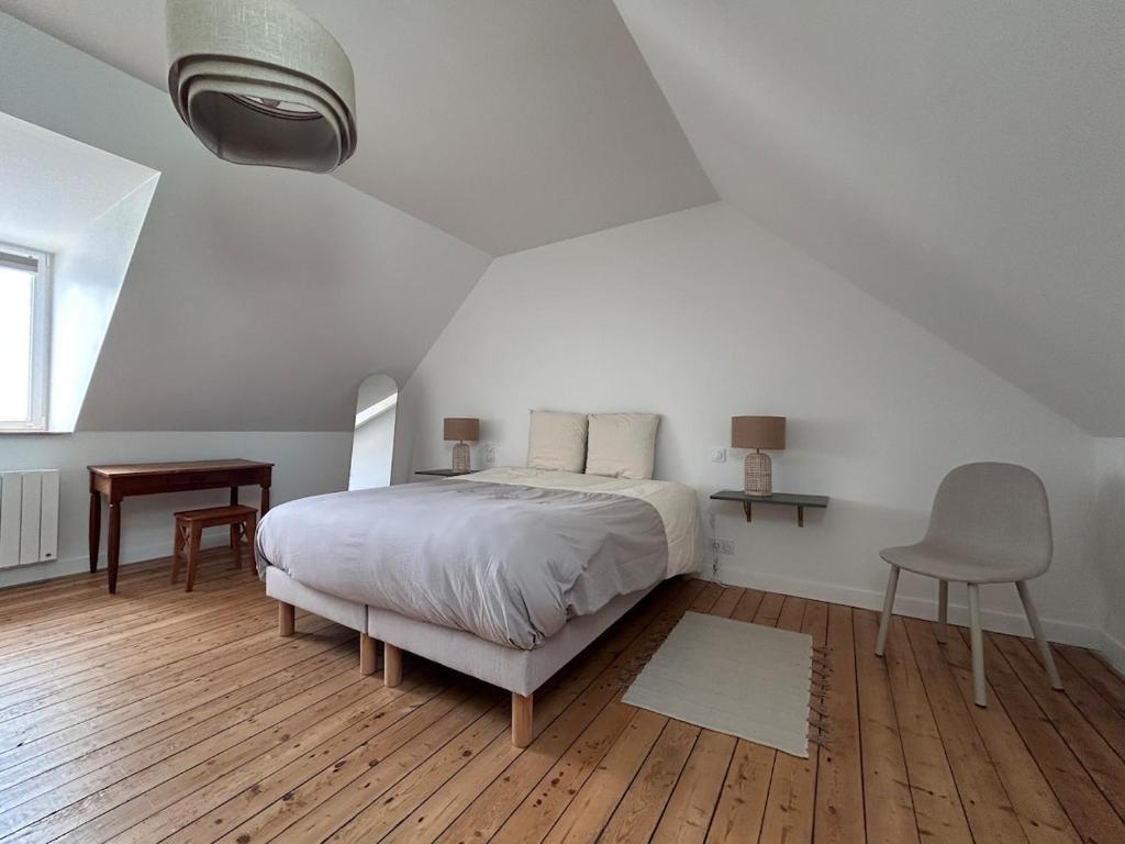 a bedroom with a bed and a desk and a chair at Au gré des marées - proche mer in Plérin