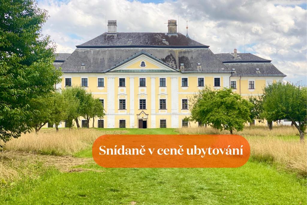 a large white house with a sign in front of it at Zámek Žďár in Žďár nad Sázavou
