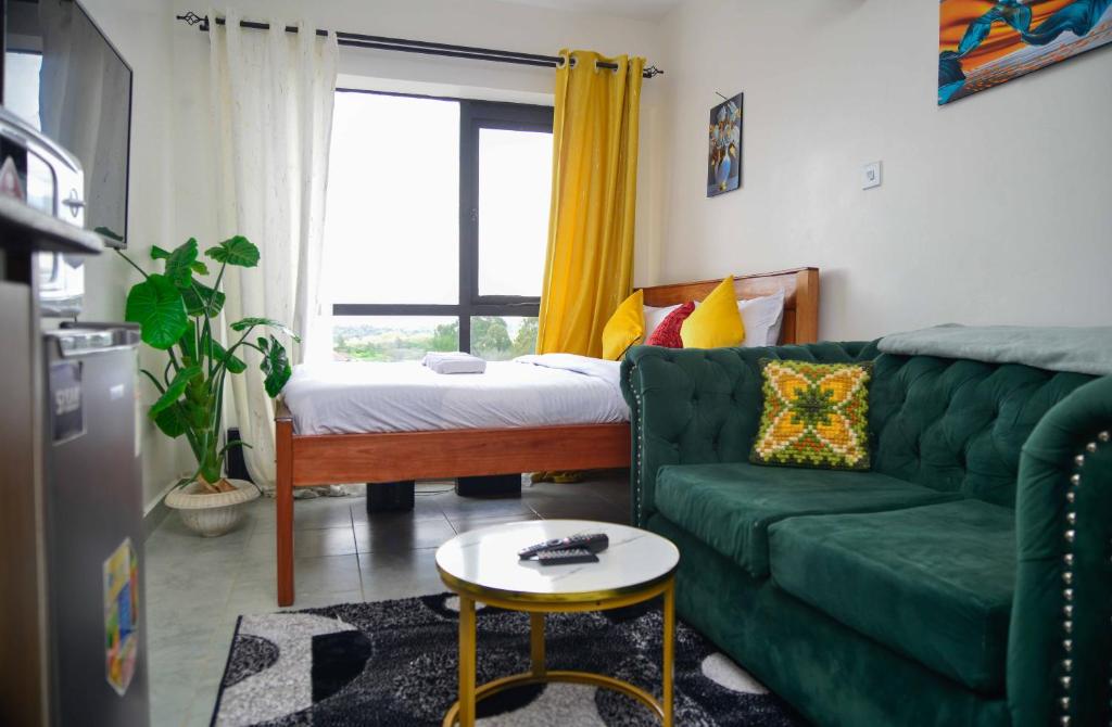 un salon avec un canapé vert et un lit dans l'établissement Stay With Moraa, à Ongata Rongai 