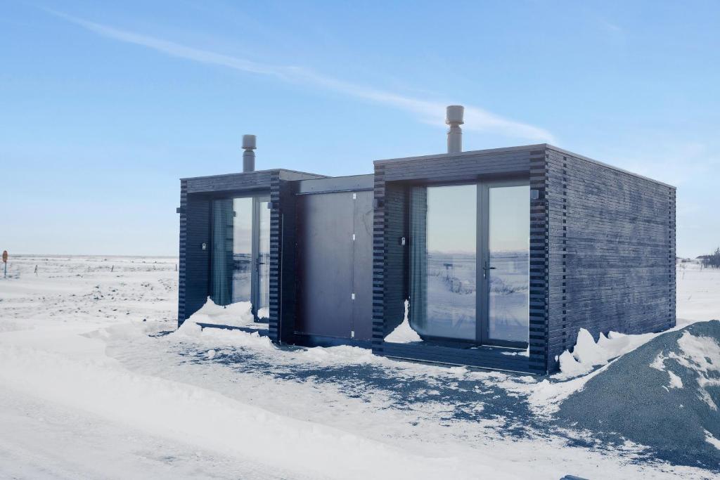 un pequeño edificio en la playa en la nieve en Modern Selfoss Studio, en Selfoss