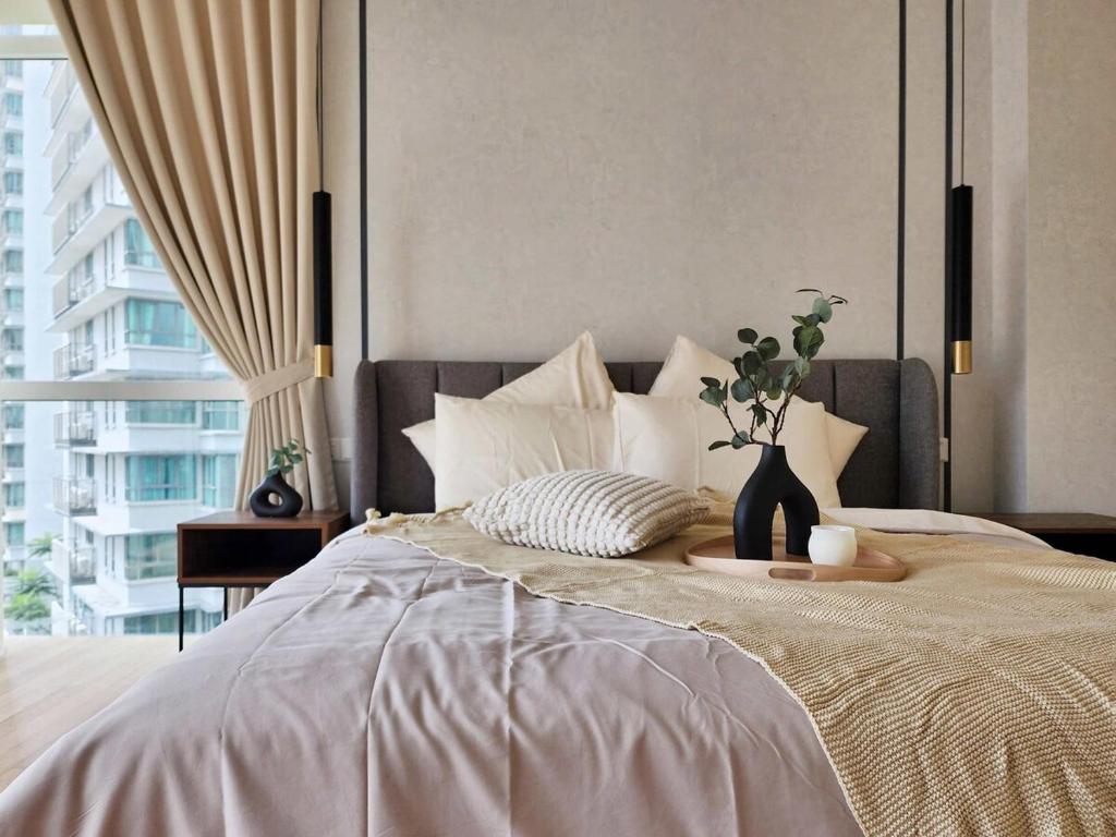 a bedroom with a bed with a vase of flowers on it at Luxury 4BR Duplex, Medini Apartment in Iskandar Puteri