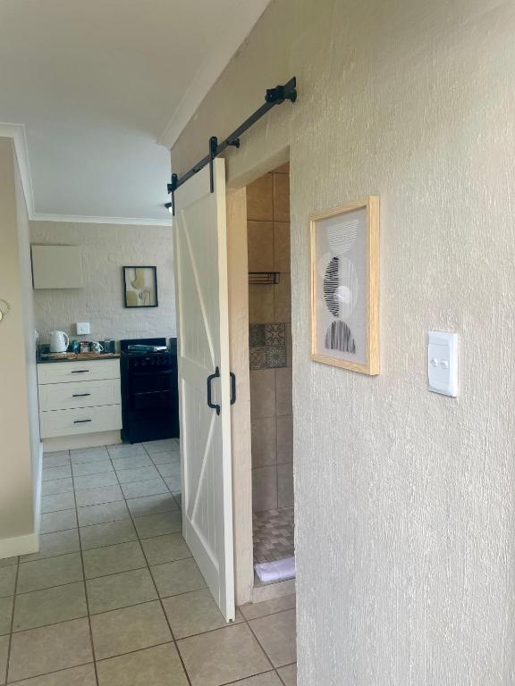 a bathroom with a shower and a door open at 42 On Fraser in Howick