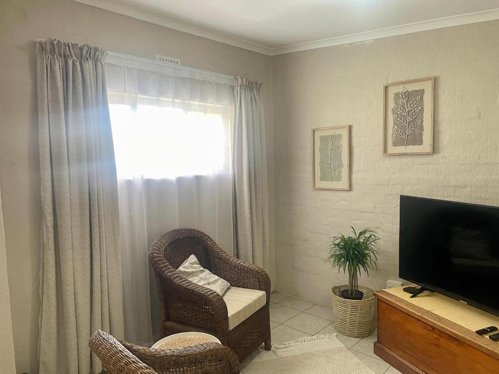 ホウィックにある42 On Fraserの椅子とテレビのあるリビングルーム