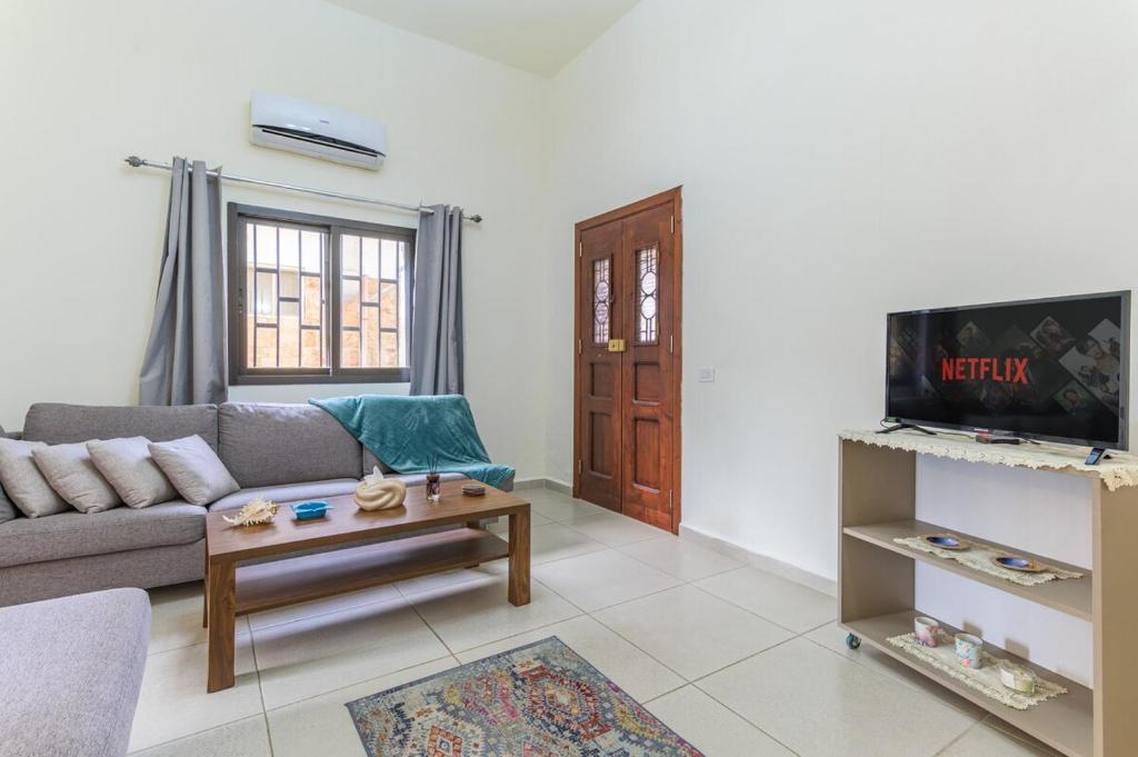 a living room with a couch and a table at Daya 2BR Apartment In Batroun in Batroûn