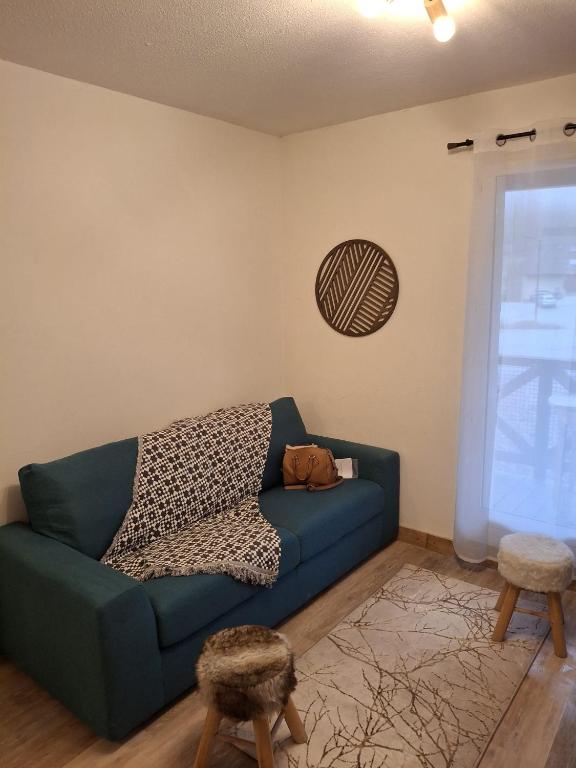 a living room with a blue couch and a window at Petit ours I N10 2P5 in Marcoux