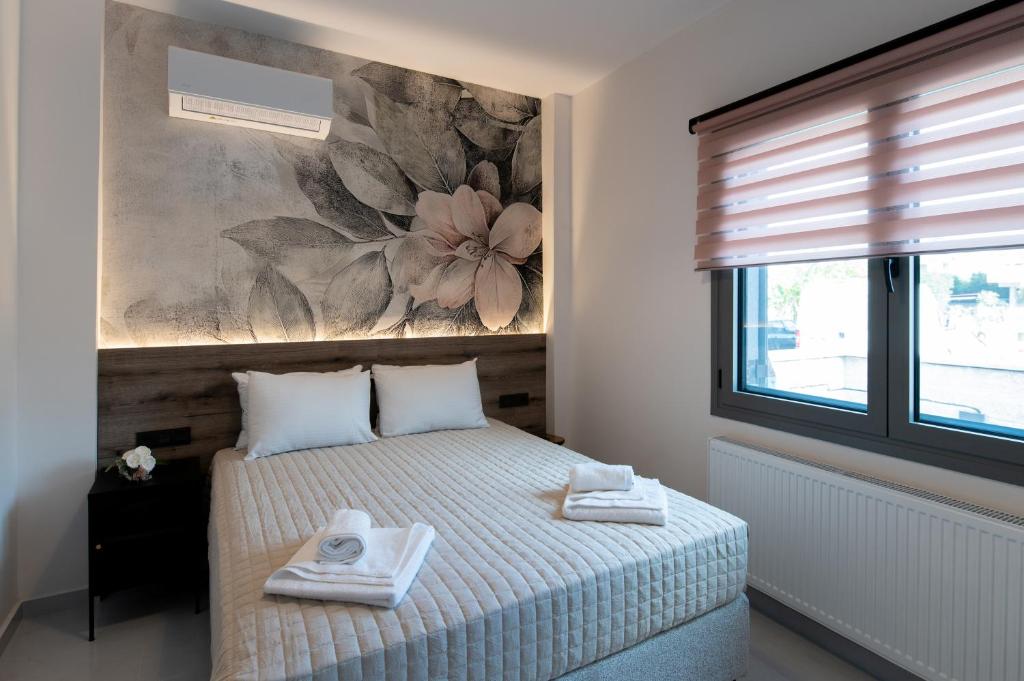 a bedroom with a bed and a painting on the wall at Lumera Urban Stay - New 2BR Home with Private Parking near Old Town in Chania