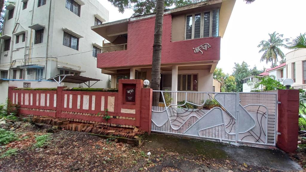 a red fence in front of a house at The Nest - Garwa in Miraj